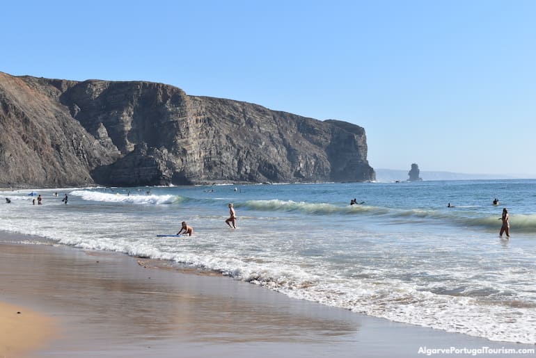 Surfing waves in Arrifana Beach, Algarve